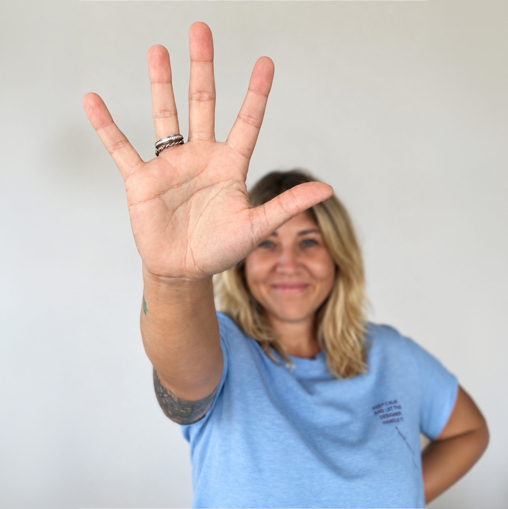 Grafikdesignerin Claudia Höller von Designkontrast mit ausgestreckter Hand vor der Kamera